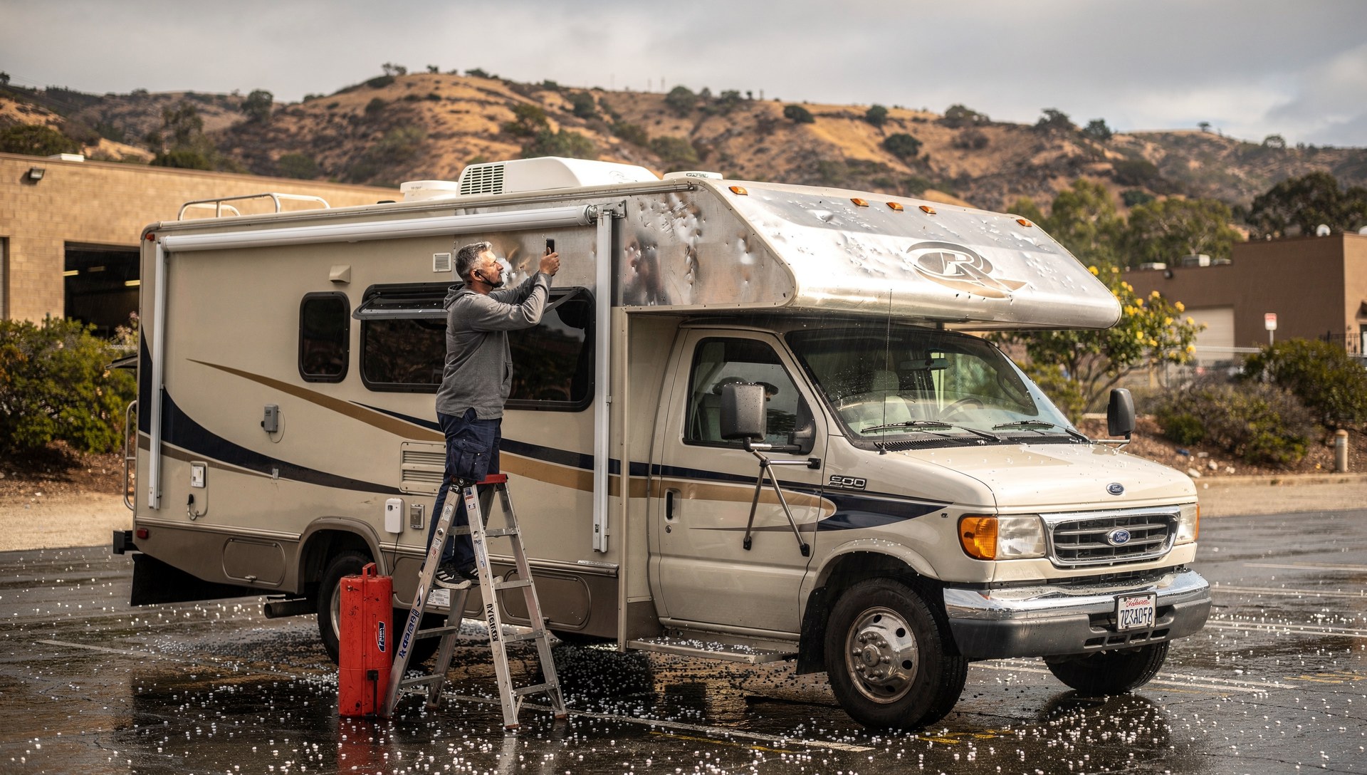 Hail-dented RV roof being documented for an insurance claim after a storm